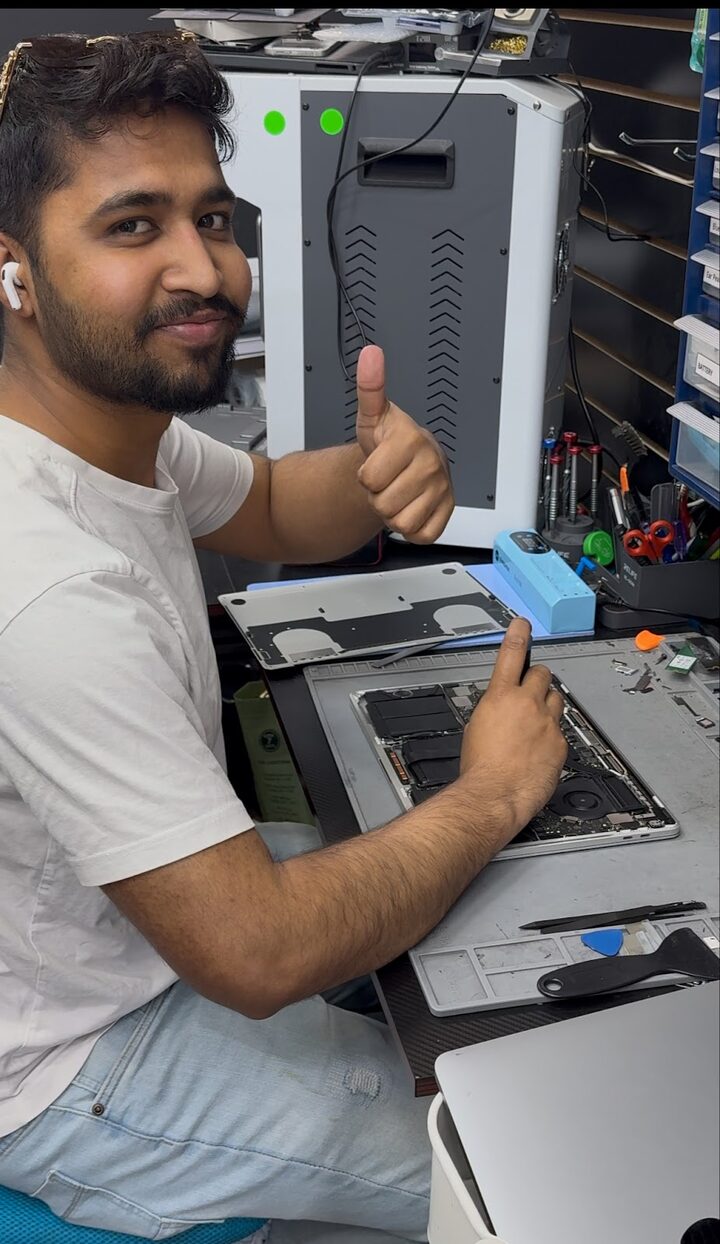 Our technician at the bench in Long Island City with an opened MacBook